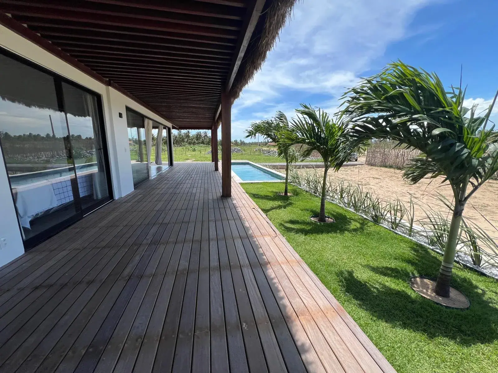 Hardwood deck, palms and garden at a VENTI house in Ilha do Guajirú