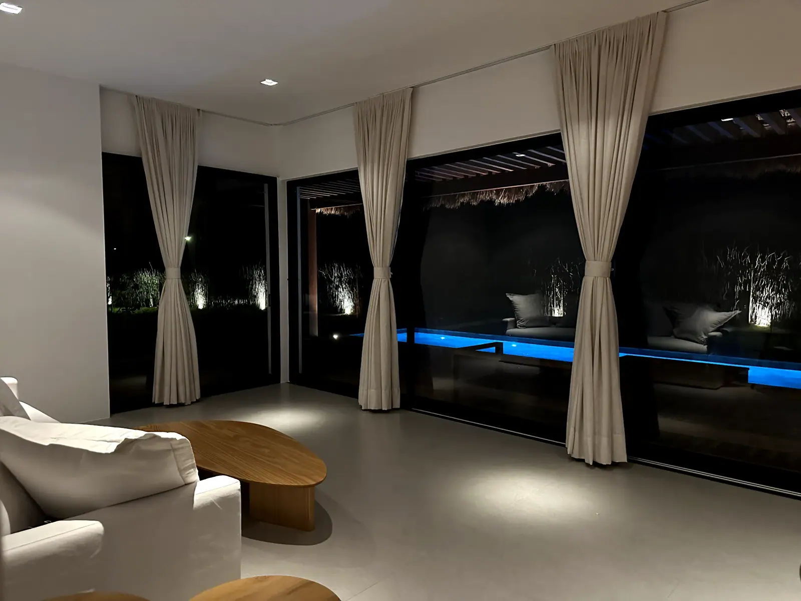 Living room with linen curtains facing the pool